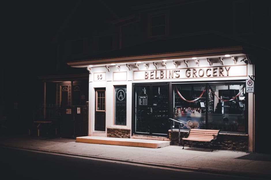 A independent corner store lit at night
